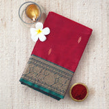 Handwoven deep red saree with shiny golden work on green border
