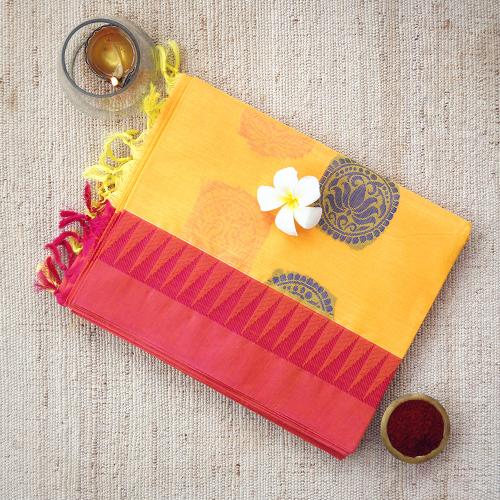 Handwoven yellow consecrated cotton saree with lotus patterns crafted in pink and royal blue