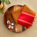 Devi Energised Cotton Saree – Golden Orange with Olive Green Floral Motifs & Vibrant Red Traditional Border