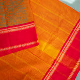 Devi Energised Cotton Saree – Golden Orange with Olive Green Floral Motifs & Vibrant Red Traditional Border