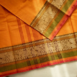 Devi Consecrated Cotton Saree – Golden Orange with Olive Green & Rust Red Traditional Floral Border