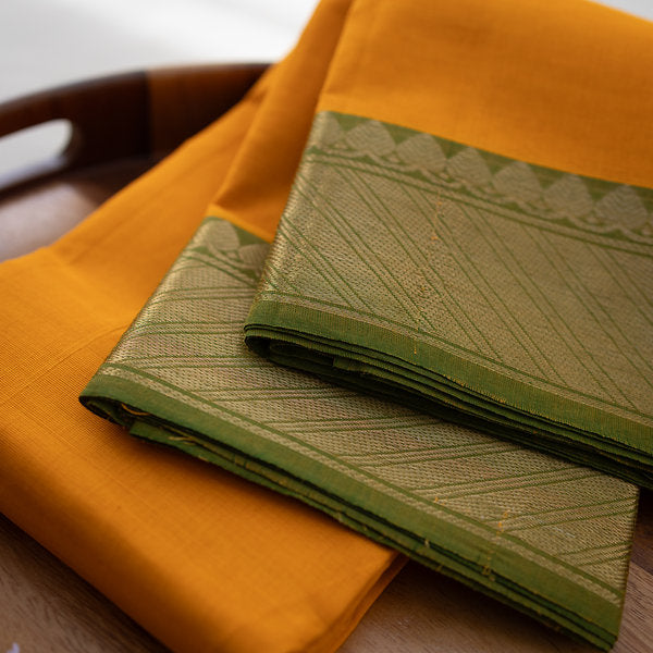 Devi Energised Cotton Saree – Golden Orange with Olive Green & Gold Geometric Border