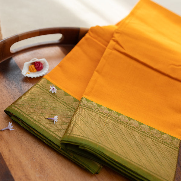 Devi Energised Cotton Saree – Golden Orange with Olive Green & Gold Geometric Border