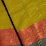Lime Green Devi Consecrated pure cotton saree with teal blue and coral golden jari peacock motif border and golden jari striped pallu.